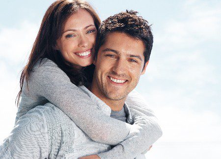 Portrait of a handsome young man giving a piggyback ride to his girlfriend